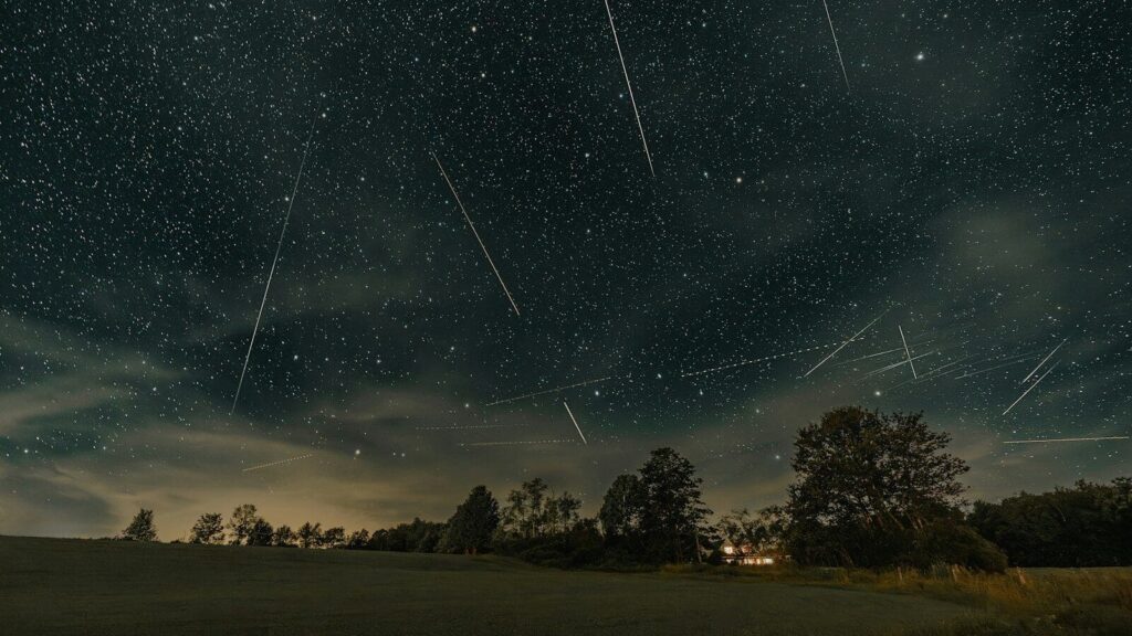 a night sky filled with stars and shooting stars